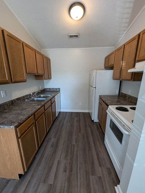 a kitchen with wood floors and white appliances